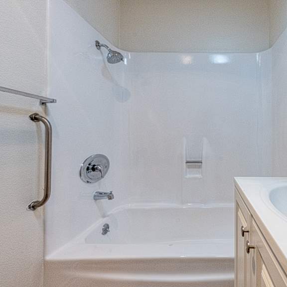 a white bathroom with a tub, sink and mirror.