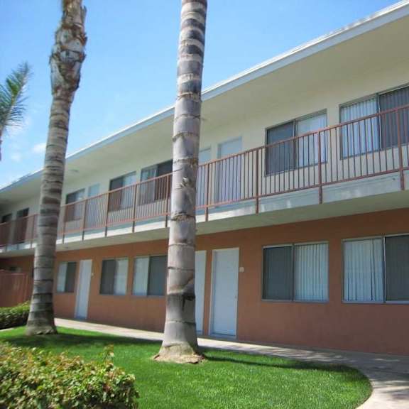 a building with a red and white exterior and a balcony with red railings.