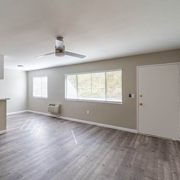 a room with a ceiling fan and a window with blinds.