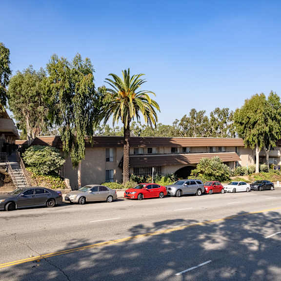 cars parked on the side of a road in front of a building.