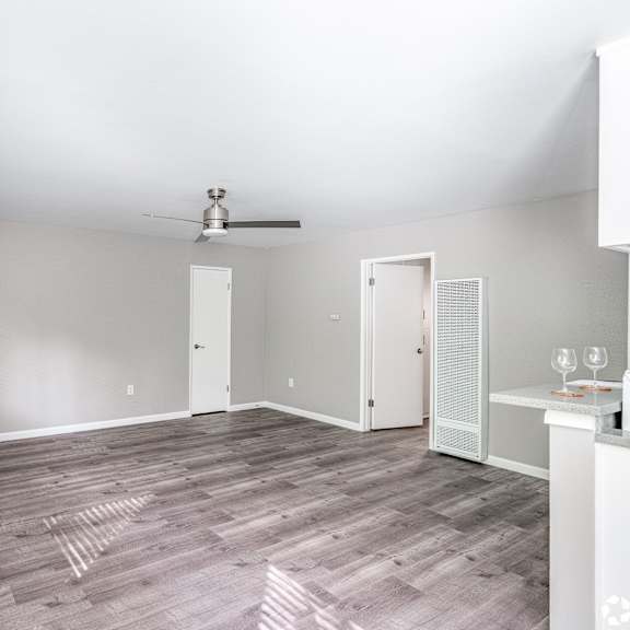 a room with a ceiling fan and a window with blinds.