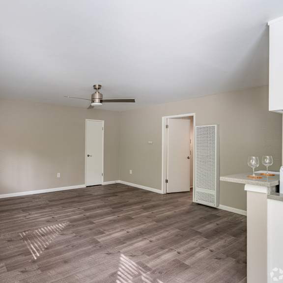 a room with a ceiling fan and a window with blinds.