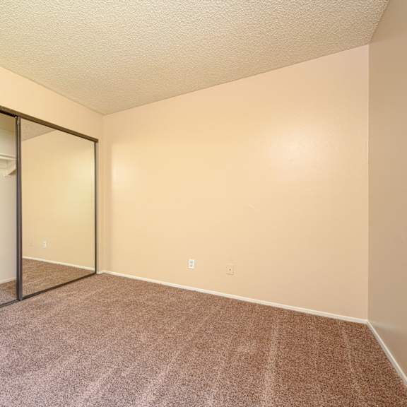 a bedroom with a closet and a window at oak terrace senior apts, hemet, 92543