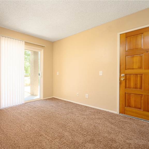 a bedroom with a door leading to a patio at oak terrace senior apts, hemet, ca