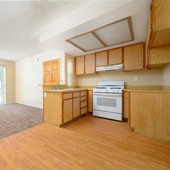 a kitchen and living room with a sliding glass door leading to a patio at oak terrace senior apts, hemet california