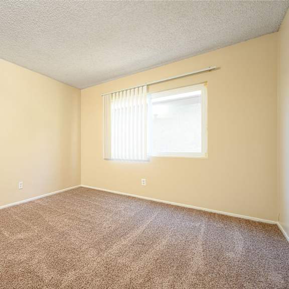 a bedroom with a window and a carpeted floor at oak terrace senior apts, california