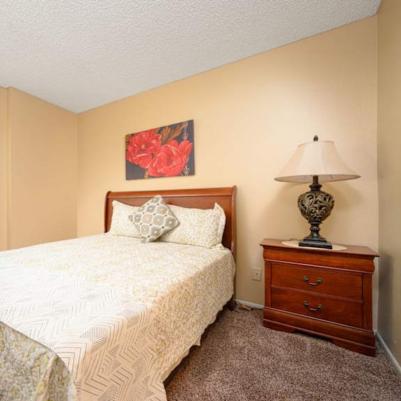 a bedroom with a bed and a nightstand at oak terrace senior apts, hemet, 92543