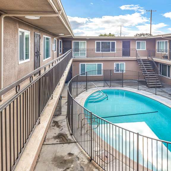 a small pool in a courtyard surrounded by a metal fence.