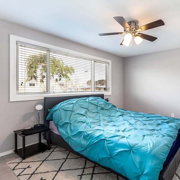a bedroom with a blue comforter on the bed.