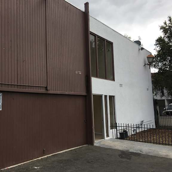 a white building with a brown garage door.