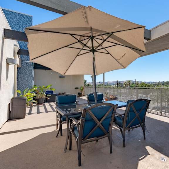 a patio with a table and chairs and an umbrella at helix at university village, california, 91766