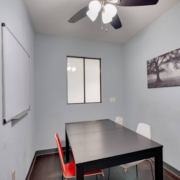 a dining room with a black table and red chairs at helix at university village, pomona, 91766