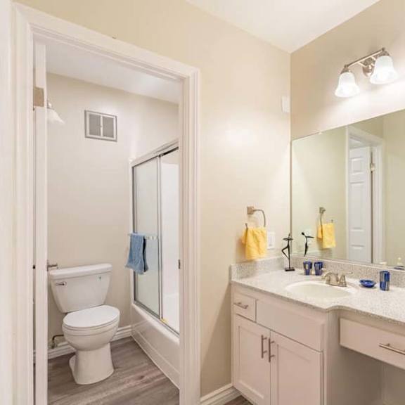 a bathroom with a toilet a sink and a mirror at mountainview venture, covina, ca