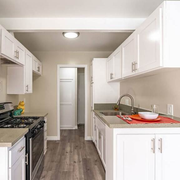 a kitchen with white cabinets and a black stove top oven at mountainview venture, california, 91722