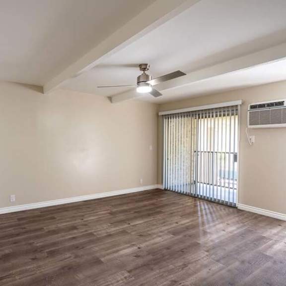 an empty room with a ceiling fan and a window at mountainview venture, covina
