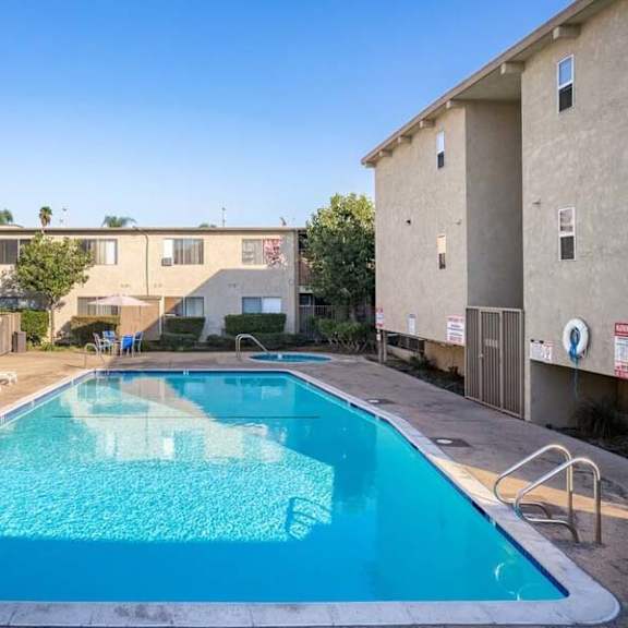 a swimming pool with chaise lounge chairs and a building in the background at mountainview venture, california
