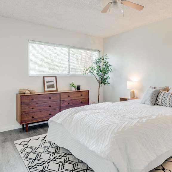 a bedroom with a white bed and a dresser at university park, azusa, 91702