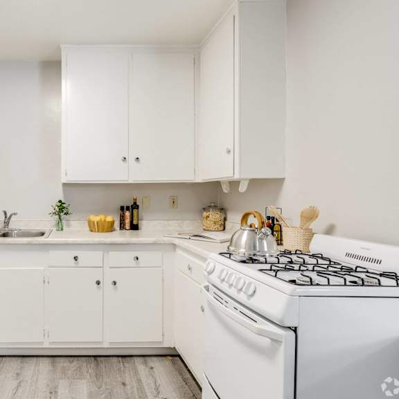 a white kitchen with white appliances and white cabinets at university park, azusa, ca
