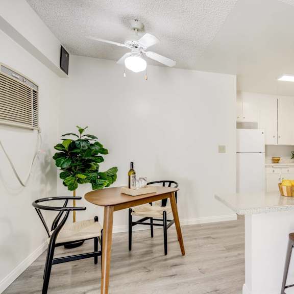 a living room with a kitchen with a bar and stools and a ceiling fan at university park, california, 91702