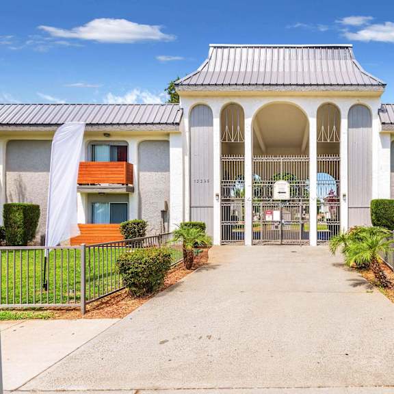 a white building with a walkway and a gate at sunnymead apts apartments, california