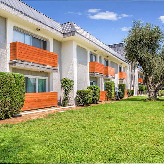 a building with a lawn and trees in front of it at sunnymead apts apartments, moreno valley, ca, 92553