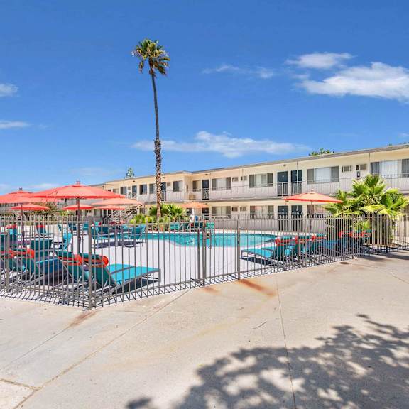 our apartments have a pool and patio with chairs and umbrellas at sunnymead apts apartments, moreno valley, ca