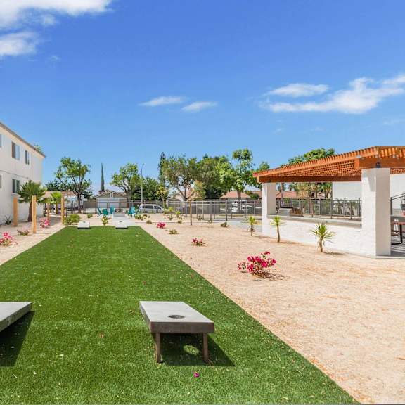 a garden outside a building with grass and benches at sunnymead apts apartments, moreno valley, ca