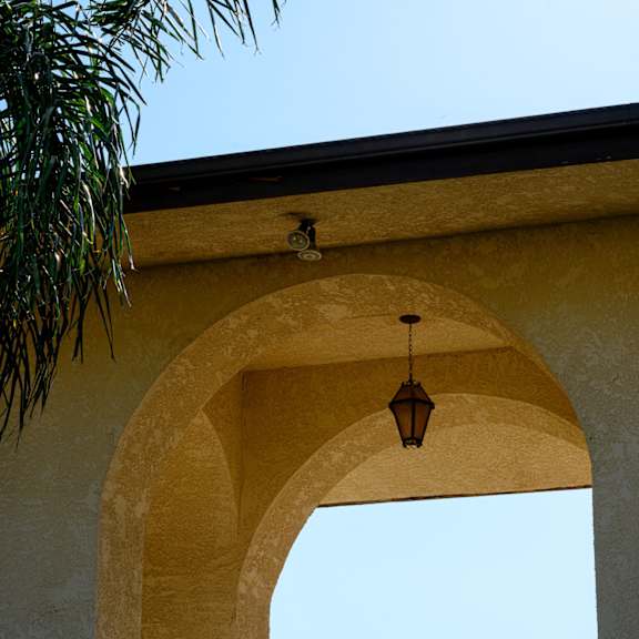 an archway with a light hanging from it with a blue sky in the background at park columbia apts, hemet, ca 92544