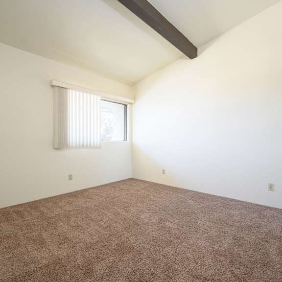 a bedroom with white walls and carpet at park columbia apts, hemet, 92544