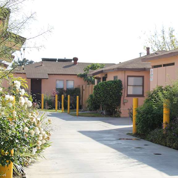 a row of houses with a sidewalk in front.