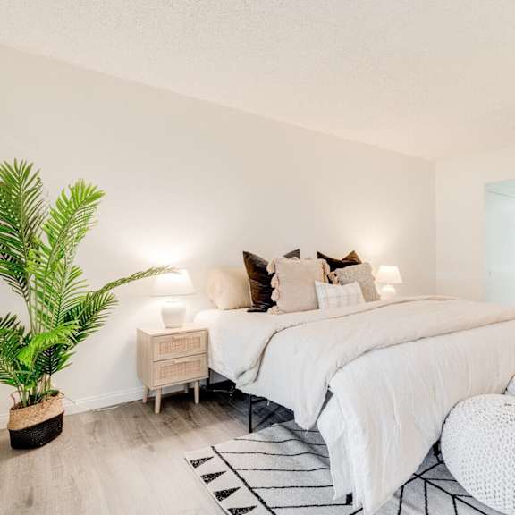 a bedroom with a bed and a potted plant at alosta place, azusa, ca