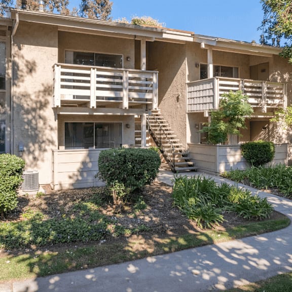 an apartment building with a sidewalk in front of it  at alosta place, azusa, ca