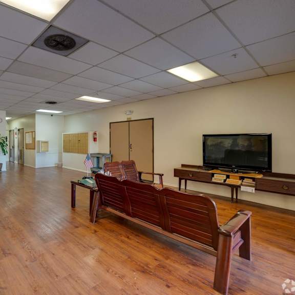 a large room with wooden floors and a television in the corner at flamingo garden senior apts, el monte, 91732