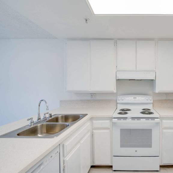 a kitchen with white cabinets and white appliances and a sink at flamingo garden senior apts, el monte, ca 91732