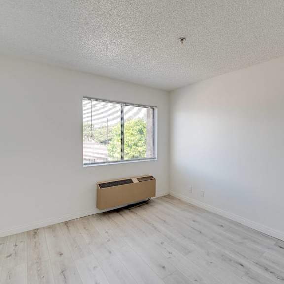 an empty room with white walls and a window at huntington terrace north senior, california