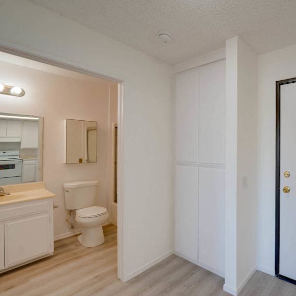 a bedroom with a door leading into a bathroom with a toilet and sink at flamingo garden senior apts, el monte california