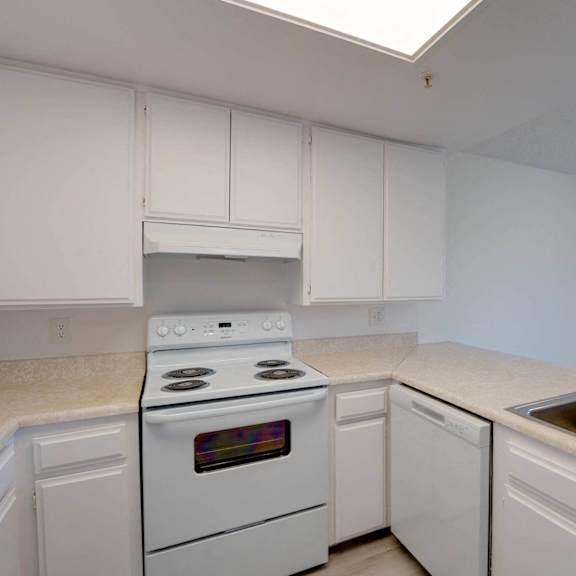 a kitchen with white appliances and white cabinets at flamingo garden senior apts, el monte