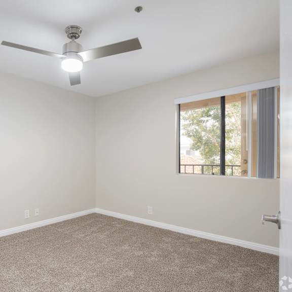 an empty room with a ceiling fan and a window at huntington terrace north senior, huntington beach, ca 92648