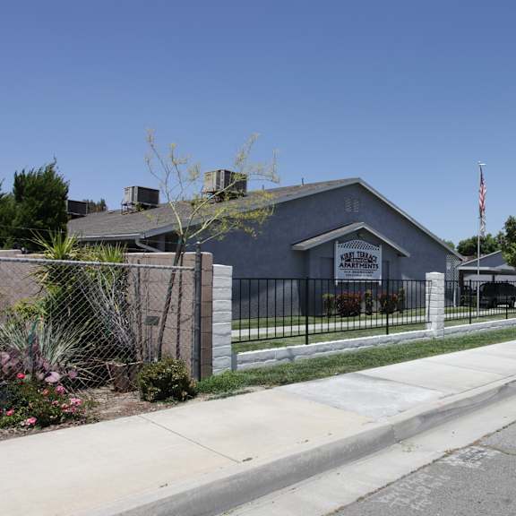 a street view with a building on the left and a car on the right.