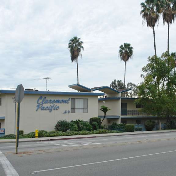 a building with a sign that says "classic hospitals" in front of some trees.