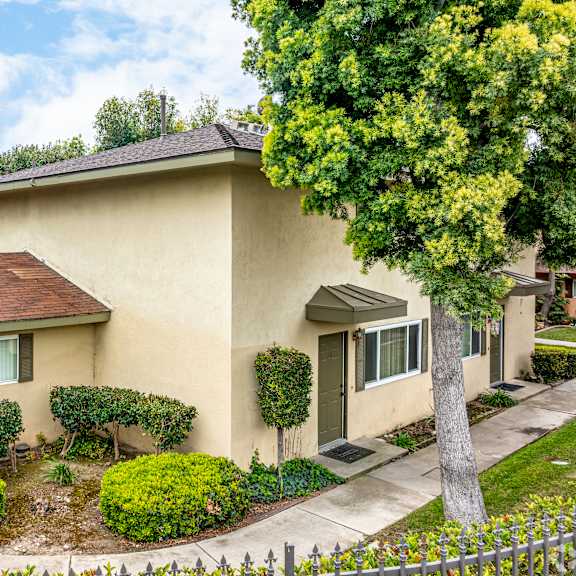 a house with a brown roof and a white fence.