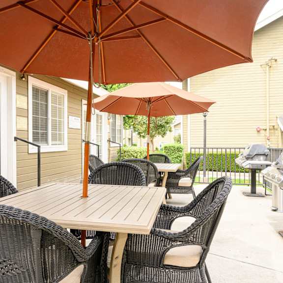 a patio with a table and chairs and an umbrella at sagewood gardens senior apartments, hacienda heights, ca 91745