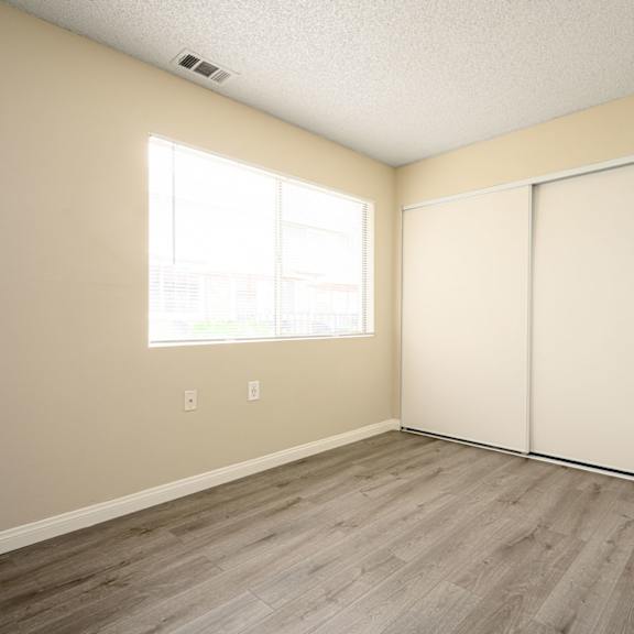 a bedroom with two closets and a window at sagewood gardens senior apartments, california