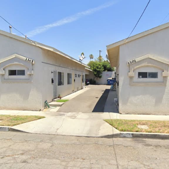 a row of small white houses with arched windows and doors.