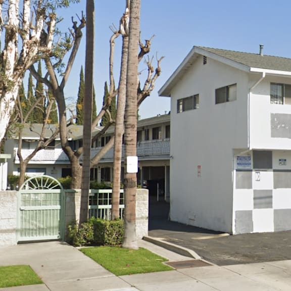 a white two-story house with a garage door and a driveway.