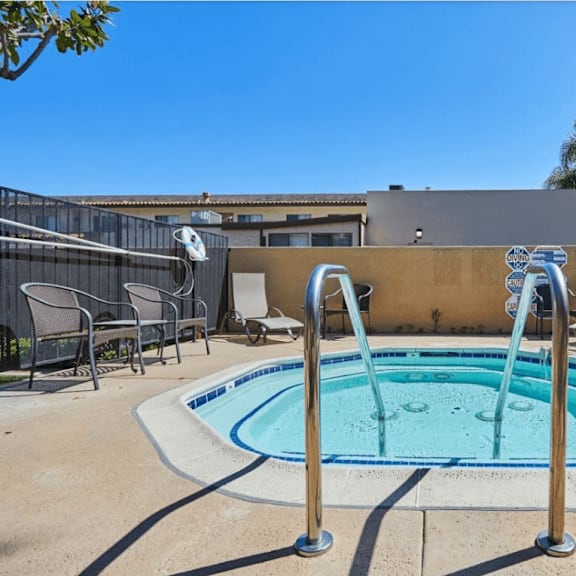 our resort style hot tub is next to our patio with chairs and a fence at huntington terrace north senior, huntington beach california