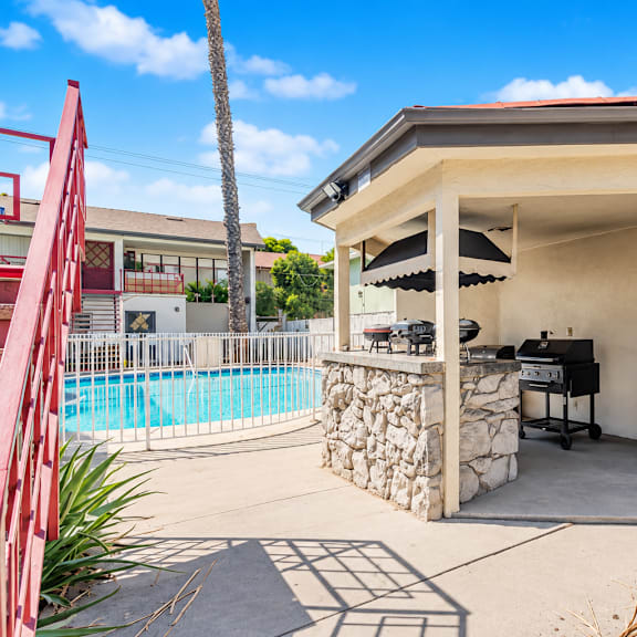 a small building with a pool in the background.