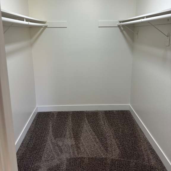 a white wall with a metal shelf and a poster on the wall.