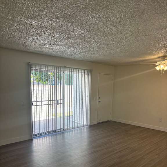 a window with blinds is in the corner of a room.