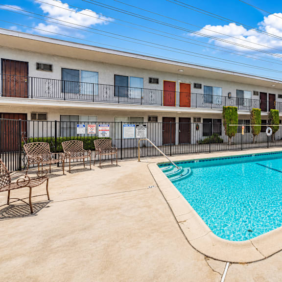 a swimming pool in front of apartment buildings.